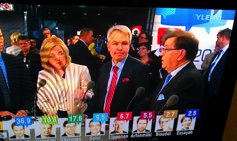 De Finse Ferry Mingelen praat met Pekka Haavisto (midden) en Paavo Väyrynen (rechts), die nek-aan-nek gingen. Uiteindelijk is de tweede plek voor Haavisto.